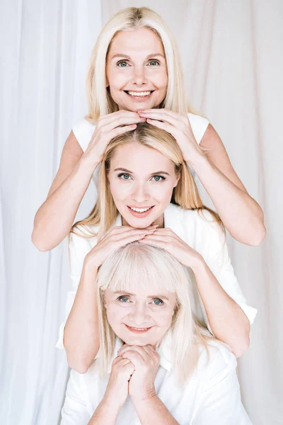 Feliz elegante de tres generaciones de mujeres rubias en trajes blancos totales - foto de stock