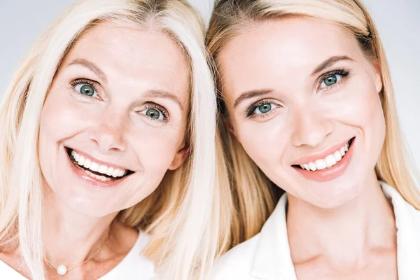 Glücklich blonde reife Mutter und junge Tochter isoliert auf grau — Stockfoto