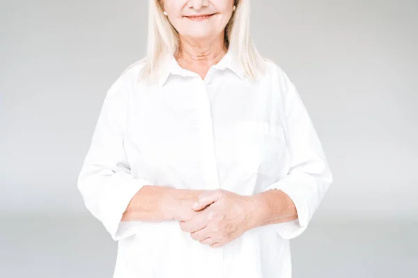Cropped view of happy blonde senior woman in white clothes isolated on grey — Stock Photo