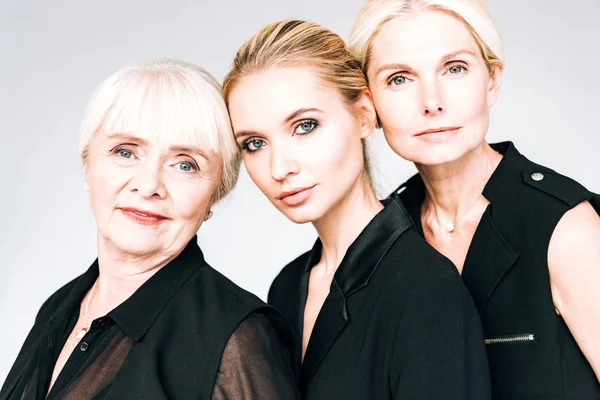 Three-generation blonde women in total black outfits isolated on grey — Stock Photo