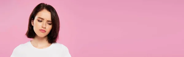 Панорамный снимок красивой грустной девушки, изолированной на розовый — стоковое фото