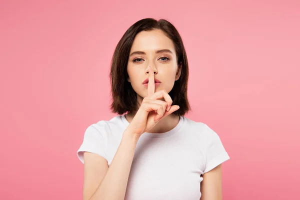 Hermosa chica mostrando silencio signo aislado en rosa - foto de stock