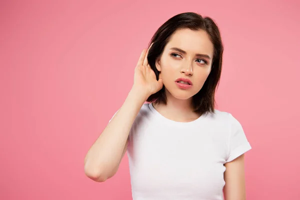 Beautiful focused girl listening isolated on pink — Stock Photo