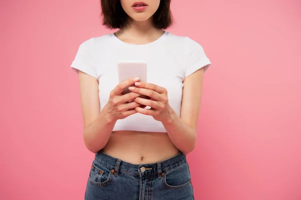 Vista cortada de mensagens de texto menina no smartphone isolado em rosa — Fotografia de Stock