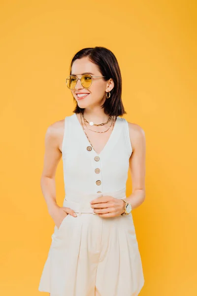 Élégante femme aux lunettes de soleil souriant isolé sur jaune — Photo de stock