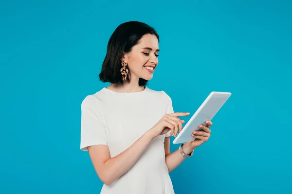 Smiling elegant woman in dress using digital tablet isolated on blue — Stock Photo