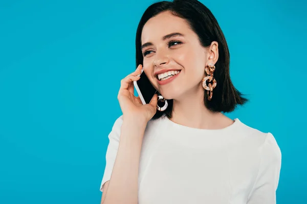 Sonriente mujer elegante hablando en el teléfono inteligente aislado en azul - foto de stock