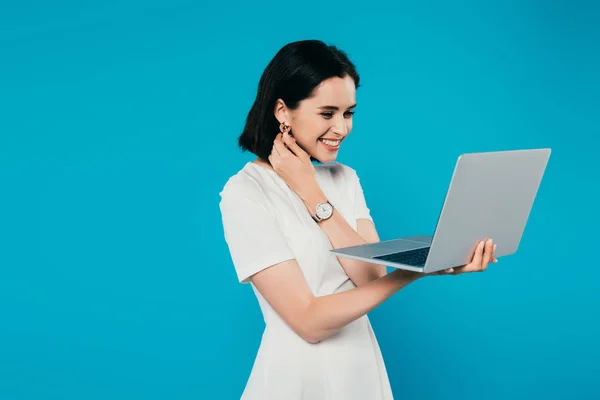 Sorrindo mulher elegante segurando laptop isolado em azul — Fotografia de Stock