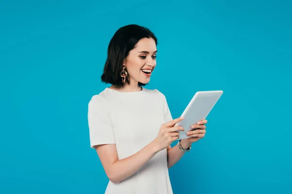 Mulher elegante animado no vestido segurando tablet digital isolado em azul — Fotografia de Stock