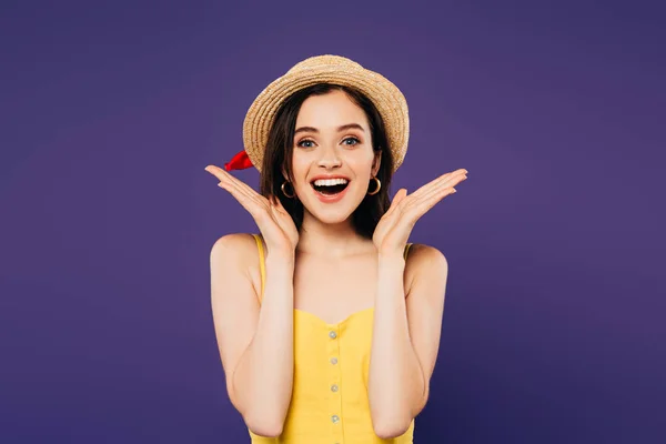 Smiling girl in straw hat showing surprise gesture isolated on purple — Stock Photo