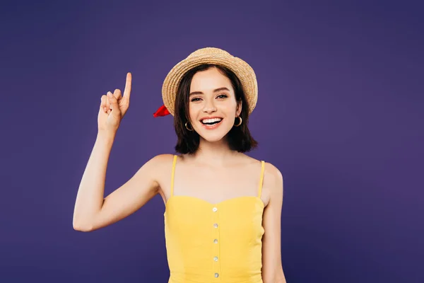 Menina sorridente em chapéu de palha mostrando gesto ideia isolado em roxo — Fotografia de Stock