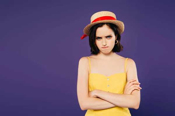 Offended girl in straw hat with crossed arms isolated on purple — Stock Photo