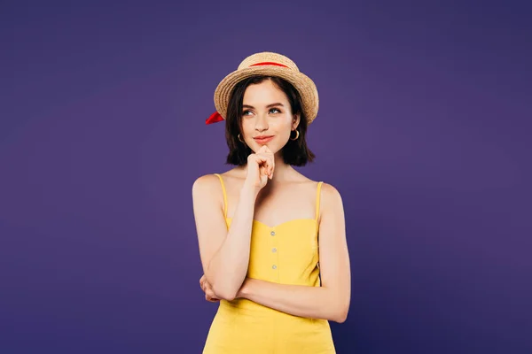 Sonhador sorrindo menina em chapéu de palha olhando para longe isolado em roxo — Fotografia de Stock