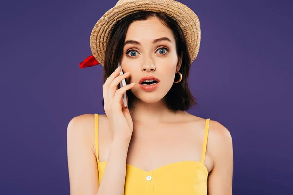 Chocó chica en sombrero de paja hablando en teléfono inteligente aislado en púrpura - foto de stock