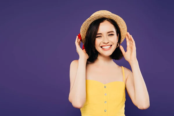 Sorrindo menina bonita com as mãos no chapéu de palha isolado em roxo — Fotografia de Stock