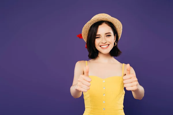 Sorrindo menina bonita em chapéu de palha mostrando polegares para cima isolado em roxo — Fotografia de Stock