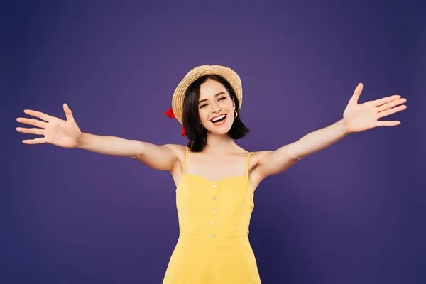 Smiling pretty girl in straw hat with open arms isolated on purple — Stock Photo