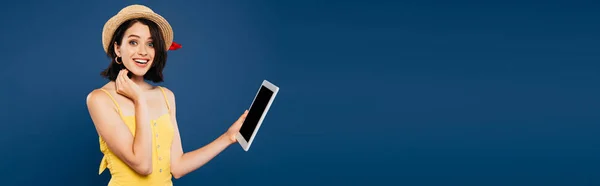 Excited girl in straw hat holding digital tablet with blanks screen isolated on blue — Stock Photo