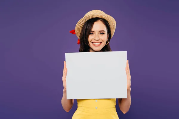 Heureuse fille en paille chapeau tenant conseil vide isolé sur violet — Photo de stock