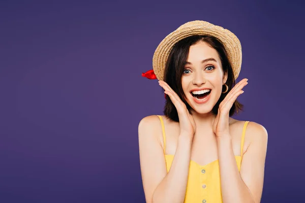 Chica feliz en sombrero de paja con las manos cerca de la cara aislado en púrpura - foto de stock