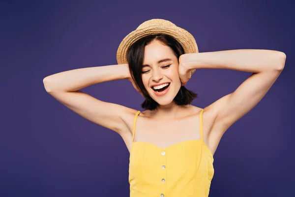 Girl in straw hat with hands on ears screaming isolated on purple — Stock Photo