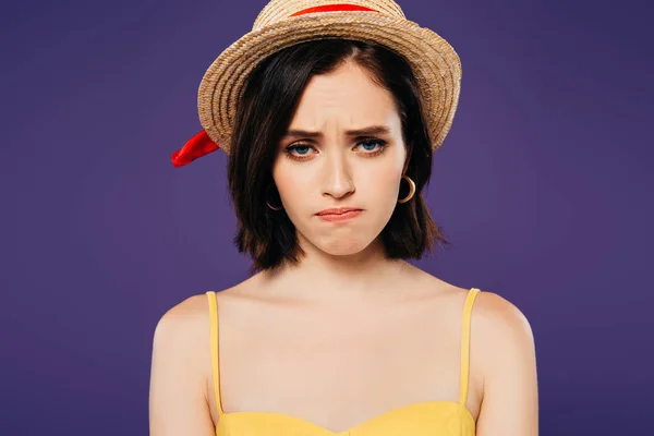 Chica triste en sombrero de paja mirando a la cámara aislada en púrpura - foto de stock