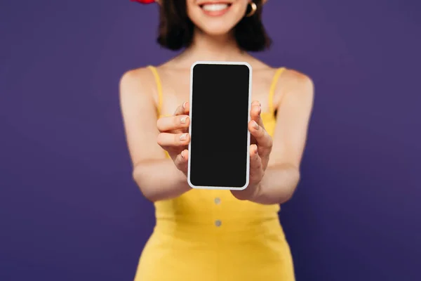 Foyer sélectif de fille souriante présentant smartphone avec écran blanc isolé sur violet — Photo de stock
