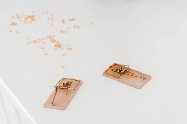 Wooden mousetraps near lentils on white table — Stock Photo