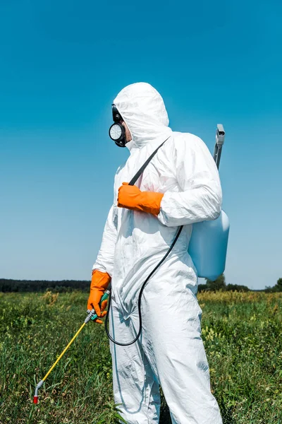 Exterminator in white uniform and latex gloves holding spray — Stock Photo