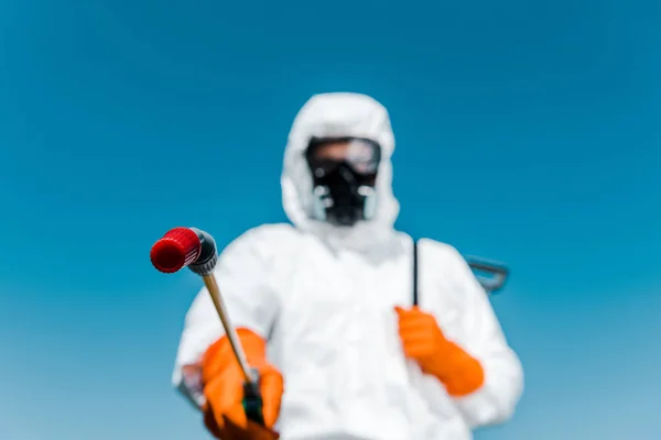 Enfoque selectivo del exterminador en uniforme blanco y guantes de látex que sostienen el aerosol exterior - foto de stock