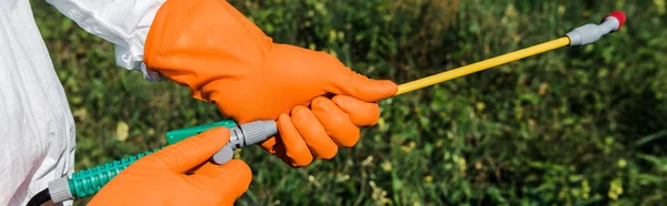 Tiro panorâmico de exterminador em luvas de látex segurando spray fora — Fotografia de Stock