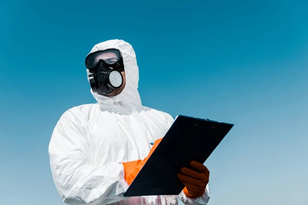 Man in protective mask and uniform holding clipboard — Stock Photo