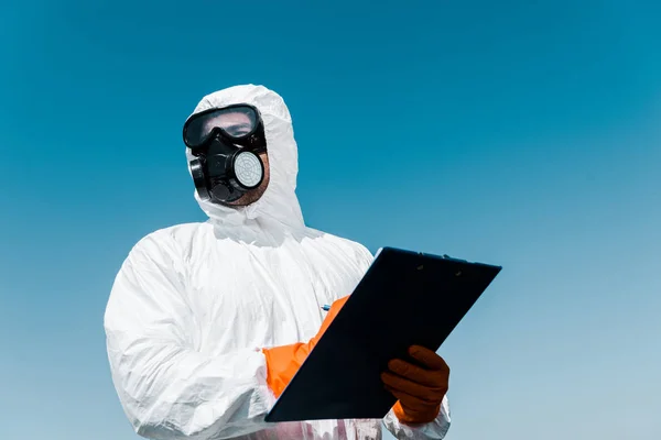 Homem em máscara protetora e uniforme segurando prancheta — Fotografia de Stock