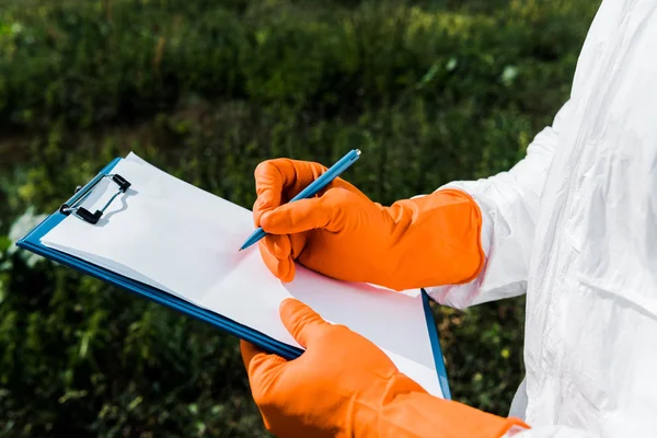 Vista recortada de la escritura exterminador mientras sostiene portapapeles - foto de stock