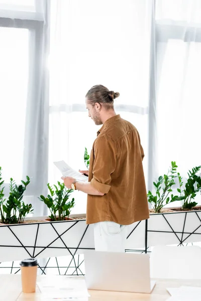 Rückansicht eines Mannes im Hemd, der im Büro Papierkram erledigt — Stockfoto