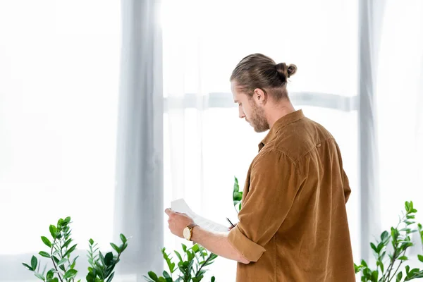 Rückansicht eines Mannes im Hemd, der im Büro Papierkram erledigt — Stockfoto