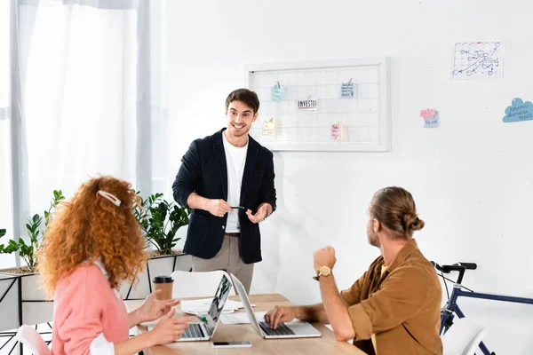 Vista posteriore di amici che guardano l'uomo sorridente in camicia — Foto stock