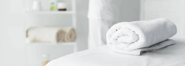 Panoramic shot of white towel on massage mat in spa — Stock Photo