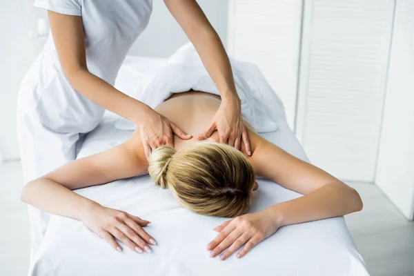 Vista cortada de massagista fazendo massagem nas costas para a mulher no spa — Fotografia de Stock