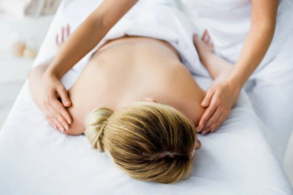 Vista cortada de massagista fazendo massagem nas costas para a mulher no spa — Fotografia de Stock