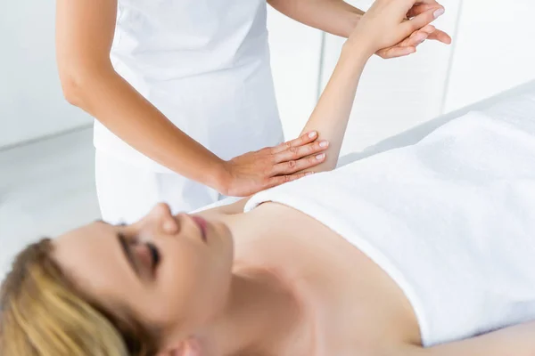 Vista cortada de massagista fazendo massagem de mão para mulher atraente — Fotografia de Stock