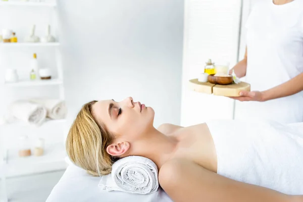 Selective focus of woman with closed eyes lying on massage mat — Stock Photo