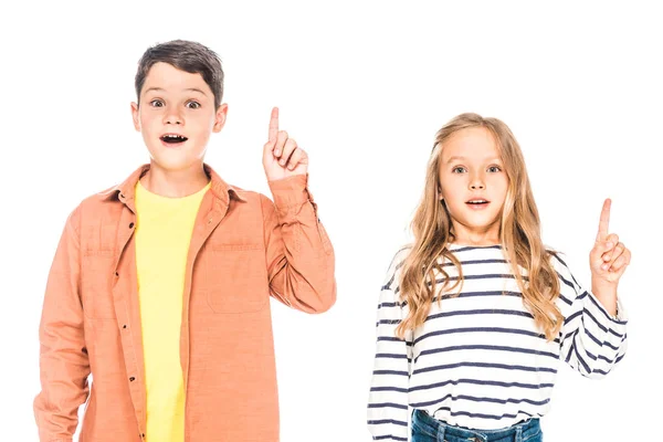 Vista frontal de dos niños sorprendidos mostrando signos de idea aislados en blanco - foto de stock