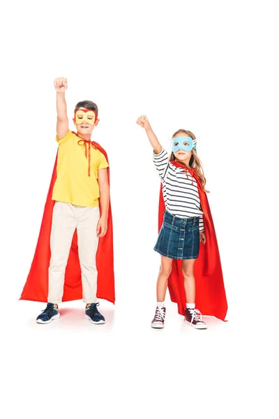 Full length view of two kids in hero cloaks holding fists up on white — Stock Photo