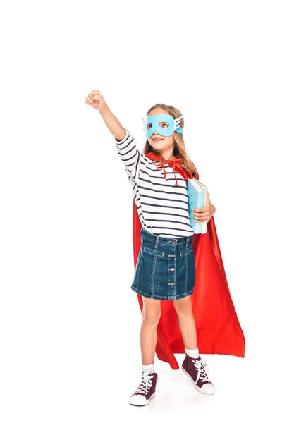 Full length view of kid in mask and hero cloak holding books isolated on white — Stock Photo