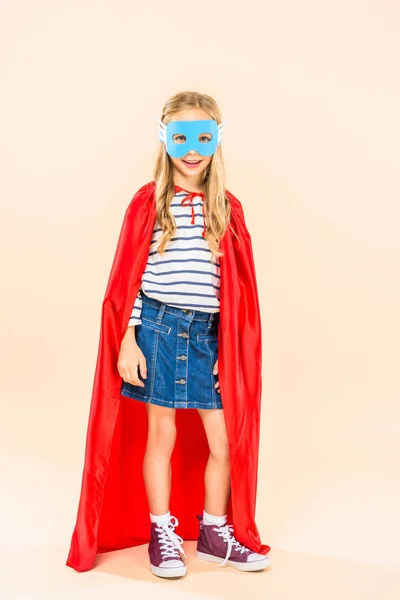 Full length view of smiling child in mask and hero cloak on pink — Stock Photo