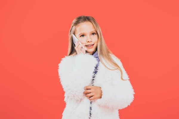 Lächelndes Kind im Herbst-Outfit spricht auf Smartphone isoliert auf Rot — Stockfoto