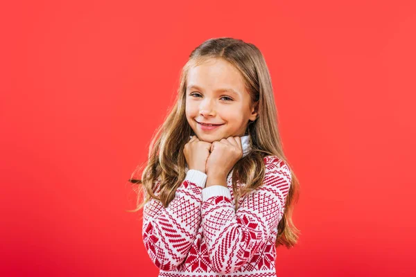 Mignon enfant souriant en pull regardant la caméra isolée sur rouge — Stock Photo