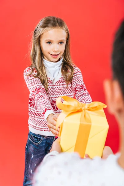 Cropped view of two kids with present isolated on red — Stock Photo