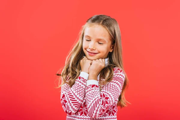 Cute child in sweater iwith closed eyes solated on red — Stock Photo